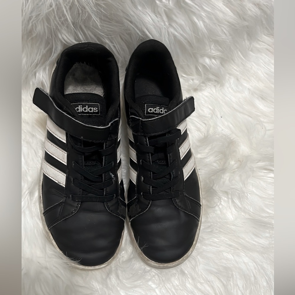 Worn out women’s Adidas Grand Court white and black sneakers